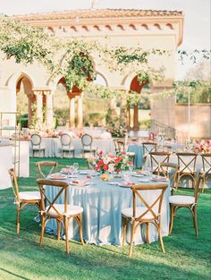 an outdoor wedding reception set up with round tables and chairs