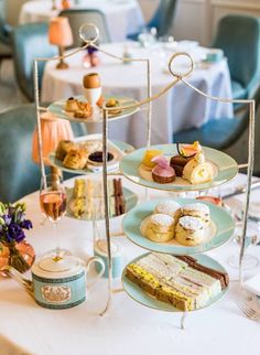 a white table topped with plates and cups filled with desserts on top of it