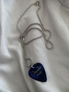 a blue guitar pick on a silver chain