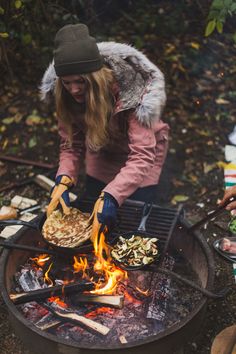 a woman cooking food over an open fire