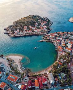 an aerial view of a small town on the water's edge with boats in it