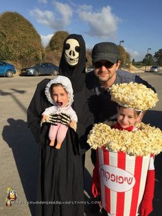 a man and two children are dressed up as movie characters with popcorn in their hands