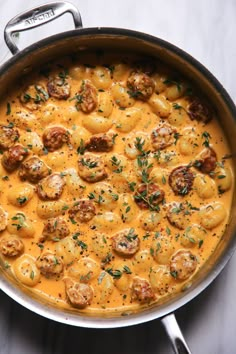 a pot filled with pasta and meatballs on top of a wooden table