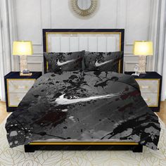 a bed with black and white paint splattered on the sheets, pillows and nightstands