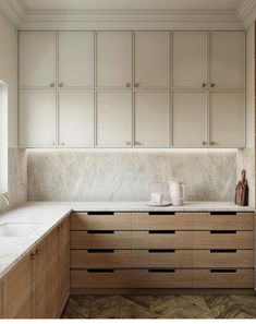 a kitchen with marble counter tops and wooden cabinets, along with a coffee mug on the counter