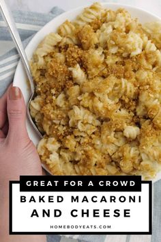 baked macaroni and cheese in a white bowl with a hand holding a spoon