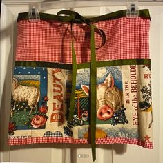 a red and white checkered apron hanging on a door