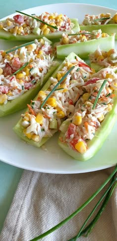 several pieces of celery with various toppings on a white plate next to green stems