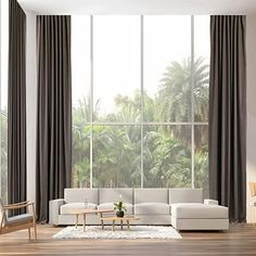 a modern living room with large windows and wooden flooring, along with white furniture