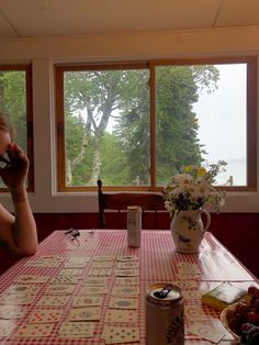 a woman sitting at a table talking on the phone