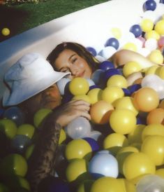 a man and woman are in a pool full of balloons