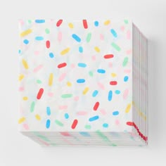 multicolored sprinkles paper napkins on a white background with red ribbon