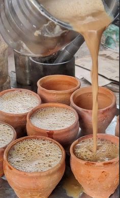 there are many clay pots that have some coffee being poured into them with the same amount