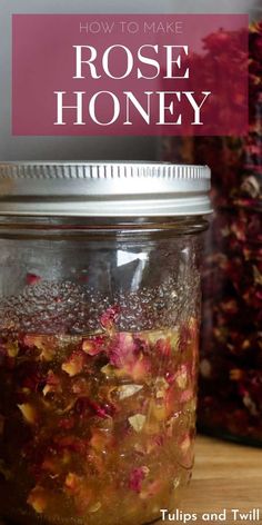 a jar filled with rose honey sitting on top of a wooden table