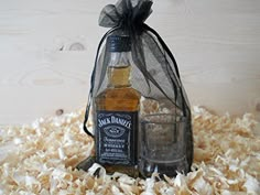 a bottle of jack daniels sitting on top of shredded wood