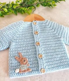 a crocheted sweater with a bunny on the front and buttoned closures