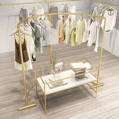 a clothing rack with clothes on hangers and a table in front of it that has a glass top