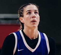 a female basketball player looking up at the ball