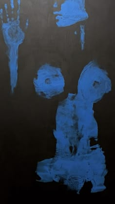 blue hand prints on black paper with white ink