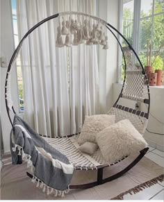 a hammock bed with two pillows on it in front of a large window