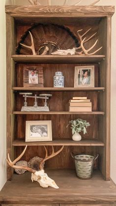 an old bookcase with antlers and pictures on it