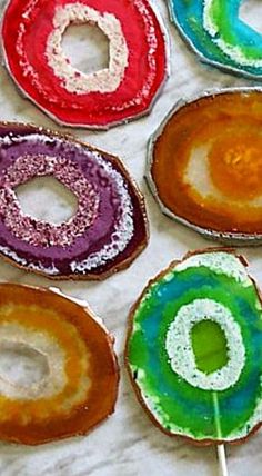 there are many different colored donuts on the table with toothpicks in them