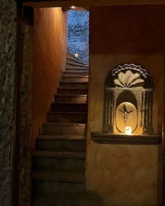 an entrance to a building with stairs and a lit candle in the doorway at night