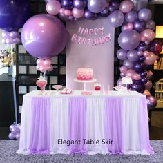 a table topped with purple and pink balloons