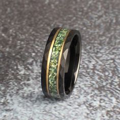 a wedding band with green moss inlays