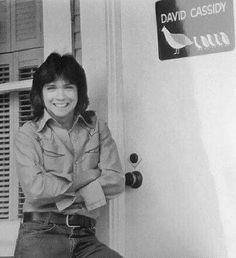 an old photo of a woman sitting on the door