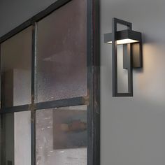 a wall light that is on the side of a building with frosted glass doors