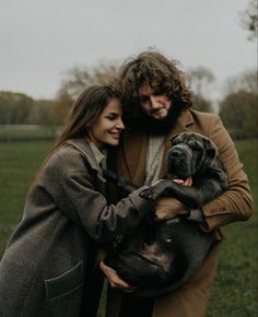 a man and woman holding a dog in their arms