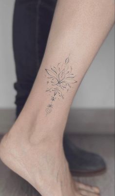 a woman's foot with a small flower tattoo on her left side calfocks