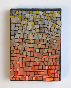 a piece of art made out of different colored bricks on a white wall with no one in it