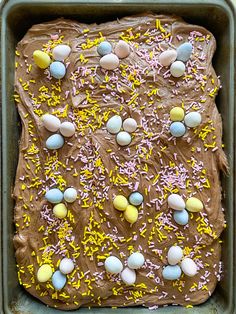 a chocolate cake with sprinkles and eggs on it in a baking pan