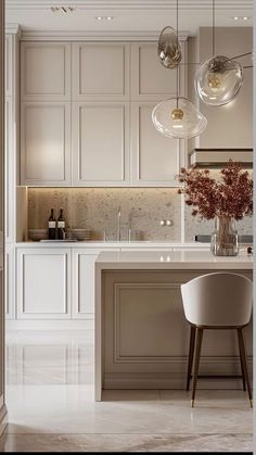 a modern kitchen with white cabinets and marble counter tops is pictured in this image, there are two pendant lights hanging from the ceiling