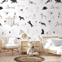 a white room with black and white dogs on the wall next to a teddy bear