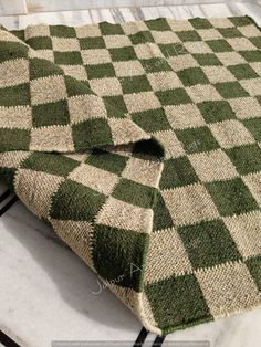 a green and white checkered blanket sitting on top of a table