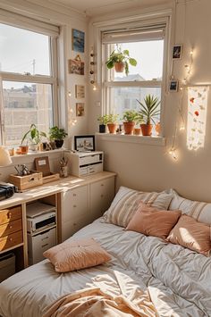 a small bedroom with lots of plants in the window sill and bed sheets on top of it