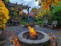 an outdoor fire pit surrounded by fall leaves