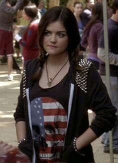 a woman standing in front of a crowd with an american flag on her t - shirt