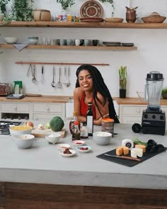 a woman sitting at a kitchen counter with food on it