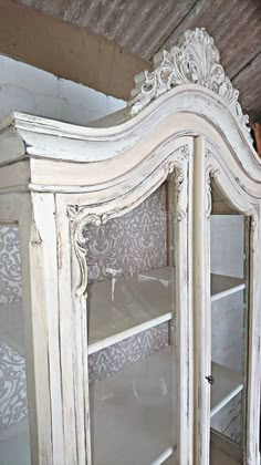 an old white china cabinet with glass doors