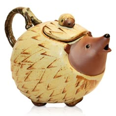 a ceramic hedgehog teapot with a lid on it's face and mouth