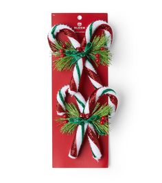 two candy canes are wrapped in green and red ribbon on a red card that says merry