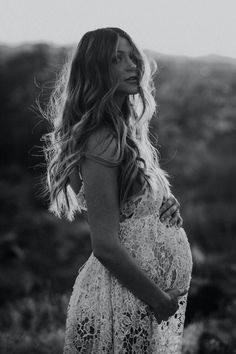 a pregnant woman standing in a field