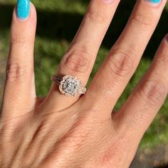 a woman's hand with a blue manicured nail polish and a diamond ring