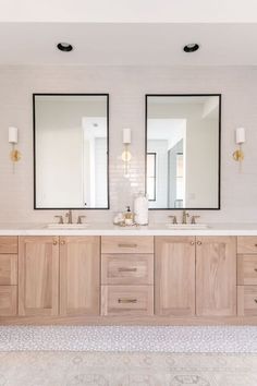 a bathroom with double sinks and two mirrors on the wall next to eachother