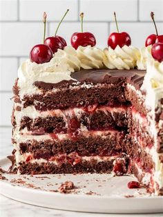 a large piece of chocolate cake with cherries on top and the rest of the cake