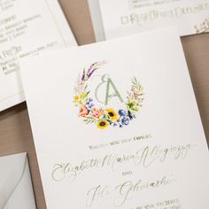 the wedding stationery is laid out on top of each other, with flowers and leaves